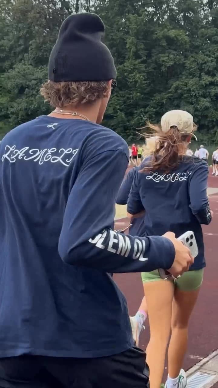 Two runners in the Lameli x GLEMOL shirt on the track